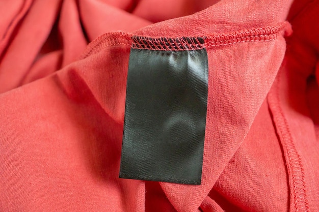 Foto etiqueta de roupa preta em branco na camiseta vermelha
