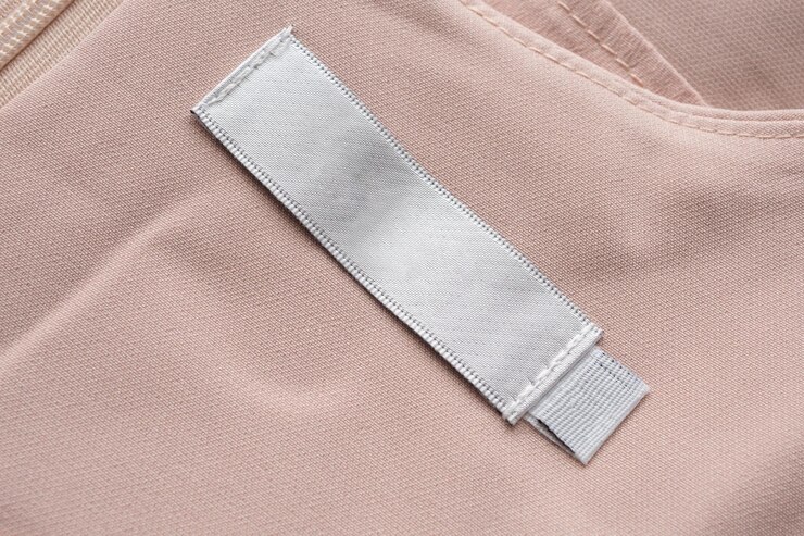 Foto etiqueta de roupas de lavanderia em branco no fundo de textura de tecido