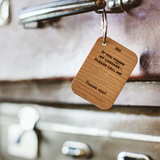 Etiqueta de equipaje de madera con la inscripción en el asa de una maleta vintage.