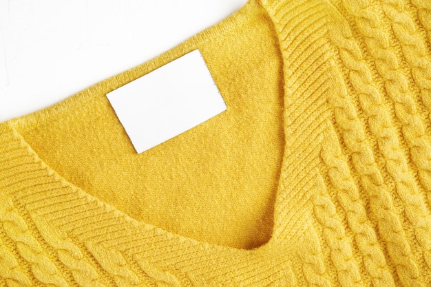 Etiqueta interior con espacio de copia en el cuello de un suéter de lana amarillo