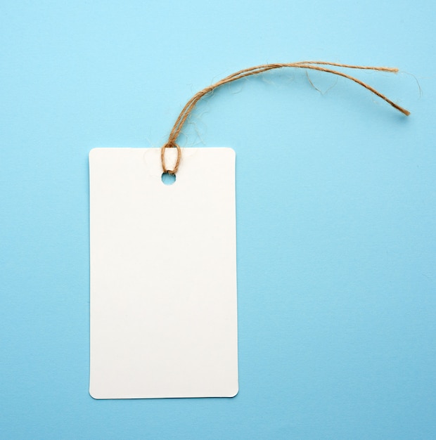 Etiqueta de papel blanco en blanco con cuerda blanca sobre azul