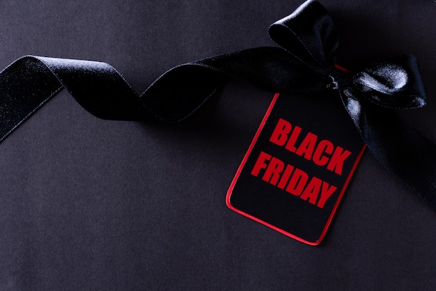 Foto etiqueta de papel negro y rojo con cinta en negro, black friday.