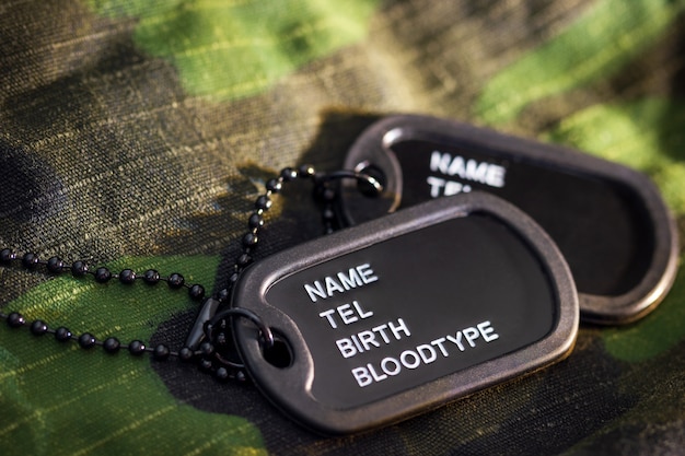 Etiqueta del soldado o etiqueta de perro colocada en la chaqueta militar y la luz del sol de la mañana