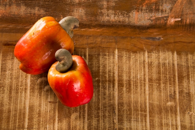 Etwas Cashewfrucht über einer Holzoberfläche.