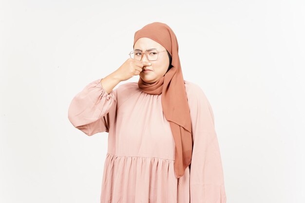 Etwas stinkendes und ekelhaftes riechen von der schönen asiatischen frau, die hijab trägt, isoliert auf weiß
