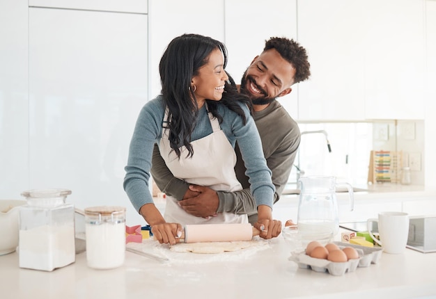 Eu adoro quando você assar. Foto recortada de um jovem casal afetuoso assando juntos na cozinha em casa.