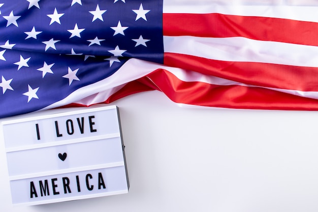 EU AMO AMÉRICA texto em uma caixa de luz com uma bandeira americana em fundo branco. Memorial Day, dia da independência, dia dos veteranos.