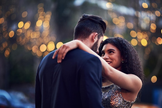 Eu amo estar perto de você foto de um jovem casal alegre abraçado enquanto se olha nos olhos do lado de fora à noite