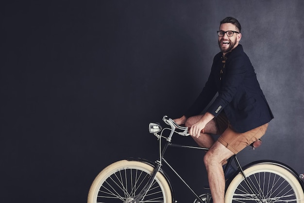 Foto eu ando de bicicleta onde quiser retrato de um jovem moderno andando de bicicleta no estúdio