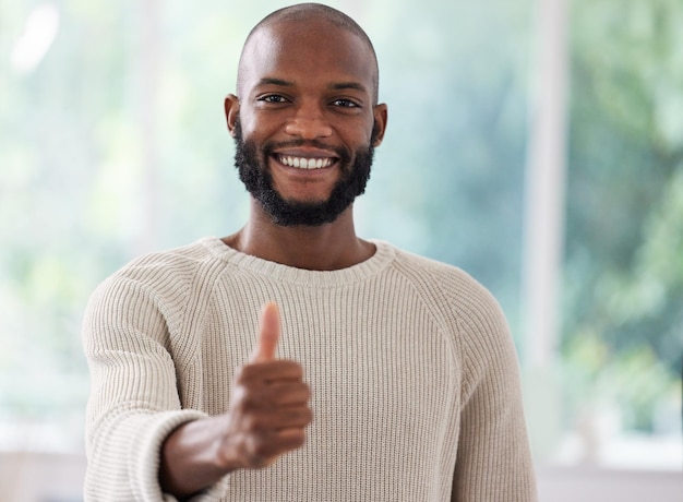 Eu aprovo Foto de um jovem mostrando um polegar para cima em casa