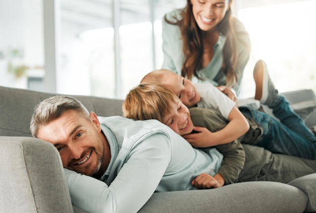 Eu me divirto mais com eles. Foto de uma família relaxando juntos em casa.