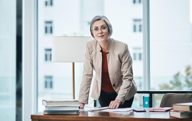 Eu não vi você ali parado Retrato recortado de uma atraente empresária madura de pé e lendo papelada em sua mesa em seu escritório em casa