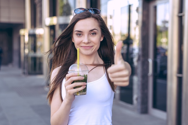 Eu recomendo você! Conceito de bebida de publicidade. Feche o retrato da foto de uma pessoa linda, muito legal, linda, linda, encantadora, dando um símbolo de ok ok na câmera