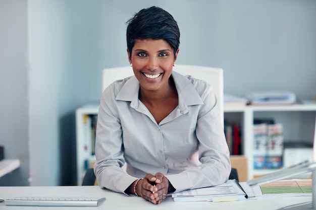 Eu sempre faço o trabalho Retrato de uma jovem empresária sentada em sua mesa em um escritório