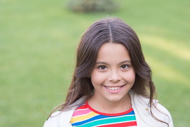 Eu sou criança feliz Aluna alegre Garota linda criança grama verde Criança feliz emocional relaxando ao ar livre Férias de verão Ideias de férias Garota sorridente feliz aproveite relaxe no gramado Retrato de perto