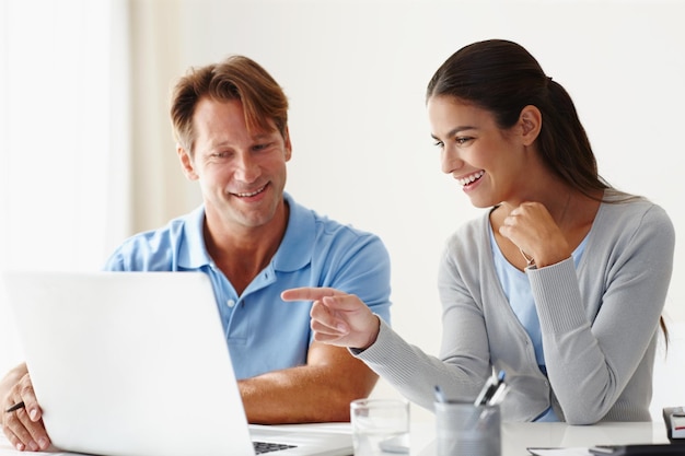 Eu vejo o que você fez lá Foto de duas pessoas usando um laptop em uma reunião descontraída