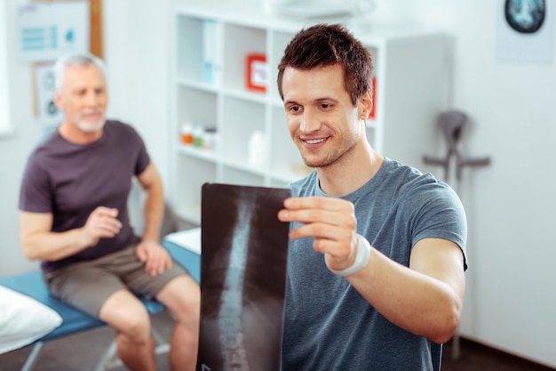 Eu vejo progresso. homem bom e positivo sendo feliz pelo paciente enquanto vê a melhora em sua saúde