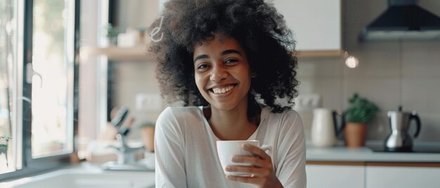 Euphorische lockerhaarige Frau genießt Kaffee in der sonnigen Küche