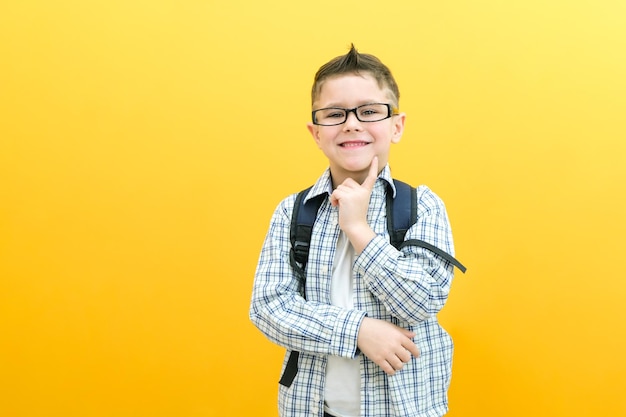 Eureka, un niño guapo con anteojos está sorprendido inspirado. Tengo una idea. Levanta el dedo índice hacia arriba. Copia el espacio aislado en un colegial de fondo amarillo.