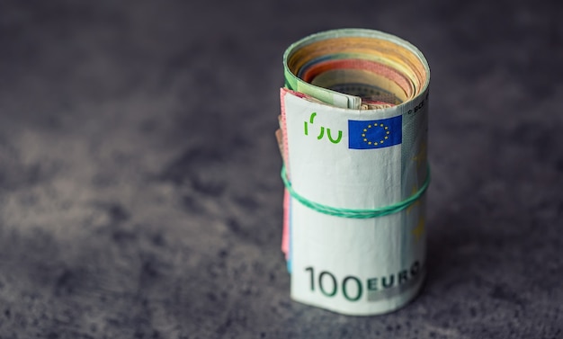 Euro-Banknoten. Euro Währung. Euro-Geld. Nahaufnahme eines gerollten Euro-Banknoten auf Beton- oder Holztisch.