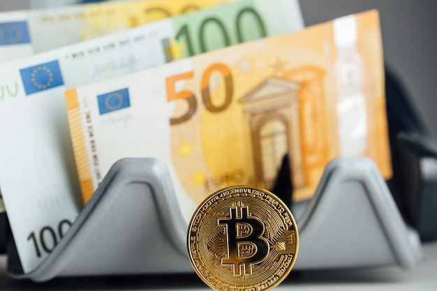 Euro-Banknoten und Bitcoin-Kryptowährungs-Investitionskonzept. Euro-Geld und Kryptowährung goldene Bitcoin-Münze.