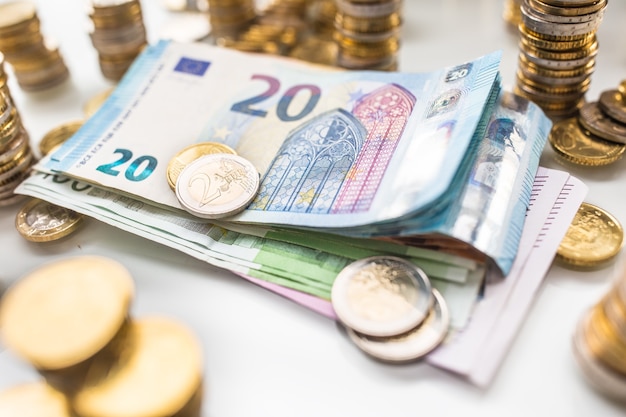 Euro-Banknoten und -Münzen togetger auf weißem Tisch - Nahaufnahme.