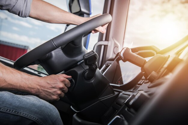 Foto euro truck driving modern semi truck cabin interior caucasian trucker colocando a mão no volante