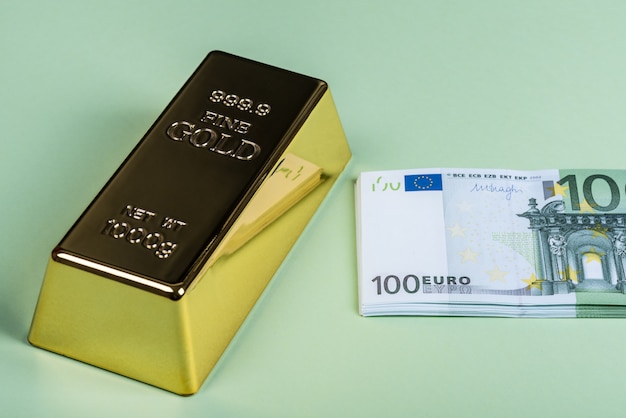 Eurobargeld und Goldbarren auf einem grünen Hintergrund