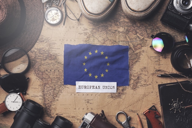 Europäische Flagge zwischen dem Zubehör des Reisenden auf alter Weinlese-Karte. Obenliegender Schuss