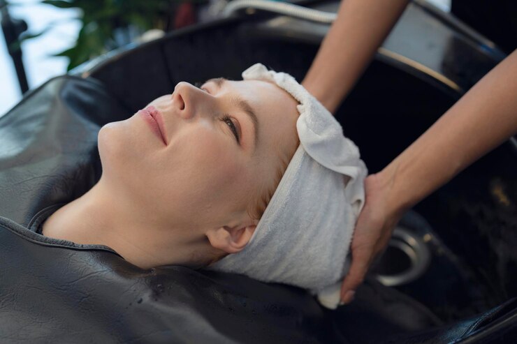 Europäische Friseurin im Schönheitssalon schneidet ihrem Kunden Haare und Haardesign