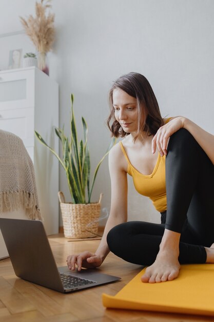 Europäische Kaukasierin macht Yoga und Meditation in ihrem Haus zu Hause beruhigendes Yoga auf einer gelben Matte