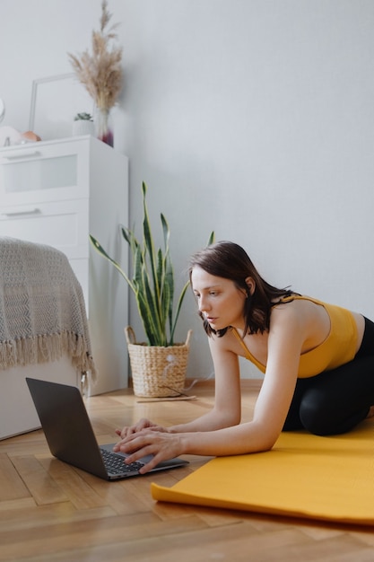 Europäische Kaukasierin macht Yoga und Meditation in ihrem Haus zu Hause beruhigendes Yoga auf einer gelben Matte