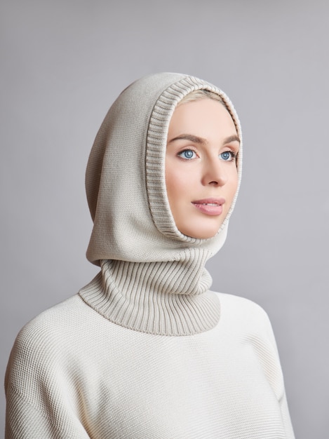 Europäische muslimische Frau mit einem blonden Haar in einer Haube, die auf ihrem Kopf gekleidet ist