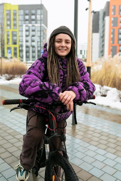 Europäische stilvolle Frau in einem informellen Aussehen fährt mit dem Fahrrad auf der Straße