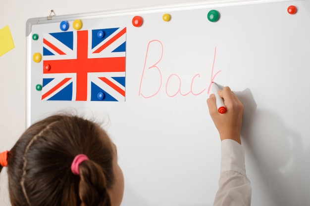 Foto europäischer schüler der grundschule, der auf whiteboard schreibt