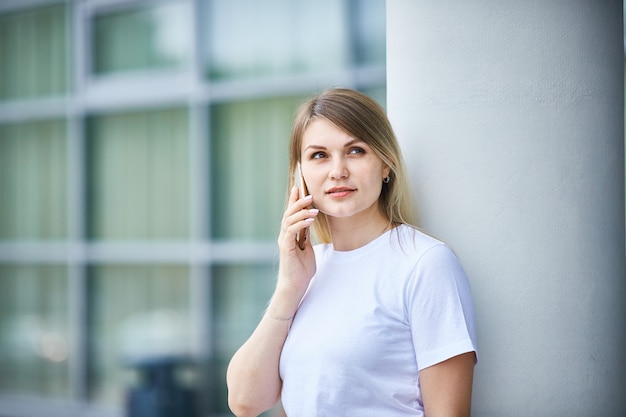 Europäisches Mädchen mit dem geraden Haar sprechend am Telefon.