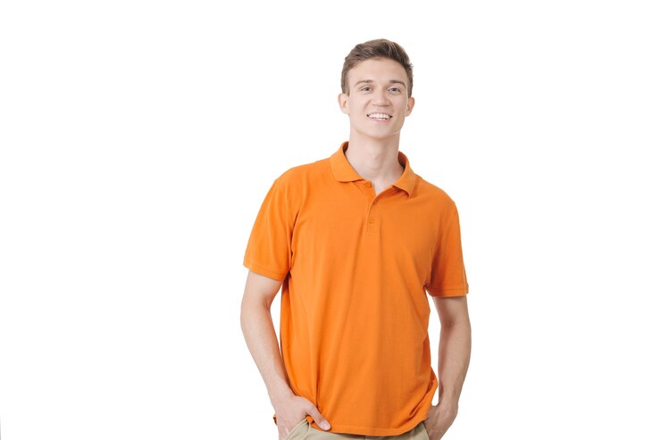 Foto europeu com aparência amigável e camisa laranja sorrindo em pé