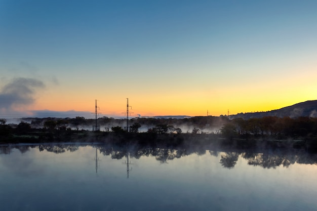 Evaporación de agua en el río al amanecer con hermoso reflejo