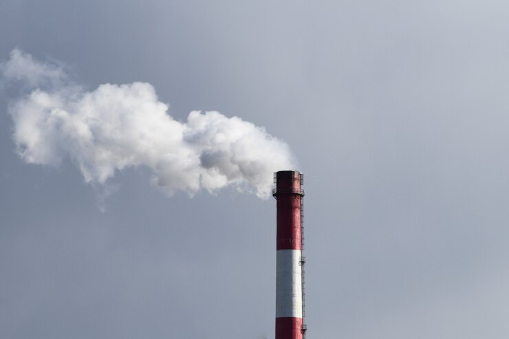 Evaporación nociva de una tubería. Chimenea de fábrica con humo blanco y cielo contaminado