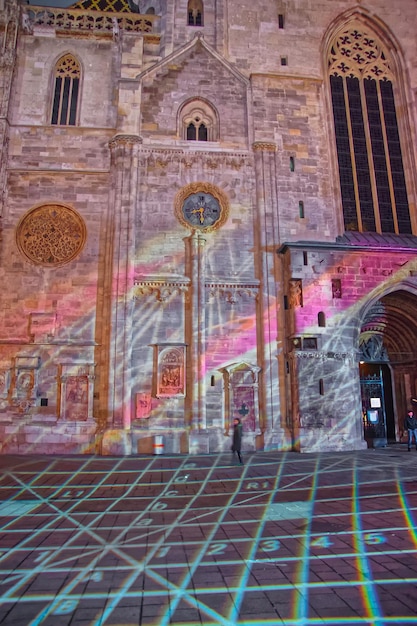 Evening Laser show na Stephansplatz na entrada da Catedral de Santo Estêvão em Viena, Áustria. Pessoas no fundo