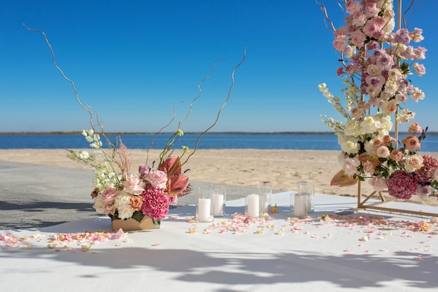 Event Dekoration. Hochzeitschuppa am Flussufer verziert mit frischen Blumen