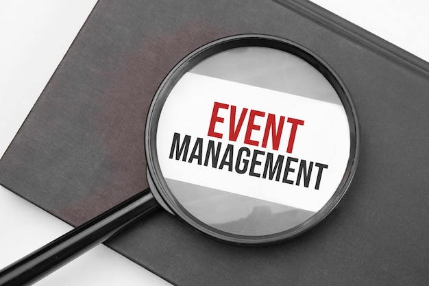 Event-Management-Wort auf Papier durch Lupe.