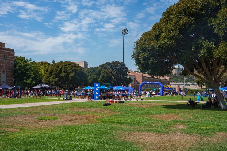 Foto evento ao ar livre vibrante no campus da ucla com tendas e arco azul
