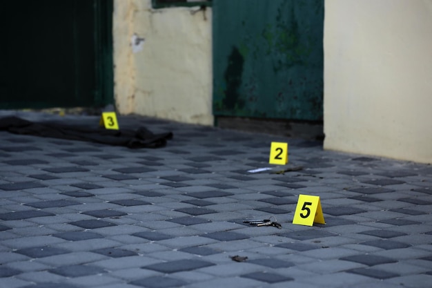 Evidência com marcador amarelo csi para numeração de provas no quintal residencial à noite conceito de investigação da cena do crime