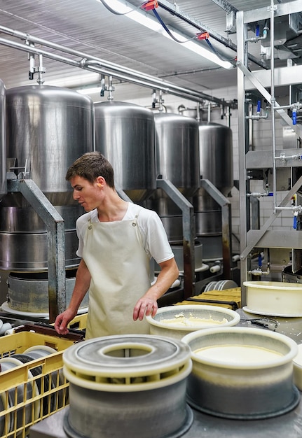 Evillers, Frankreich - 31. August 2016: Käser bringt Gruyere de Comte-Käse in die Formen in der Molkerei in Franche Comte, Burgund, in Frankreich.