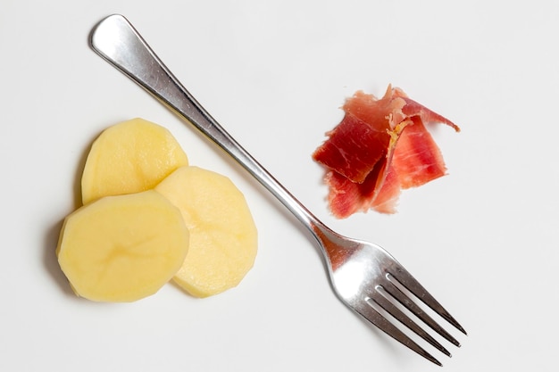 Evocación cruda de un plato tradicional de la cocina mediterránea patatas con jamón