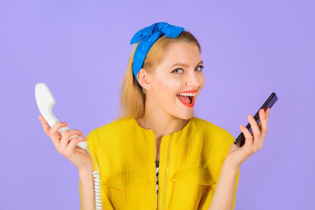 Evolución tecnológica mujer elegante sostiene teléfono con cable celular mujer sonriente en diadema sostiene