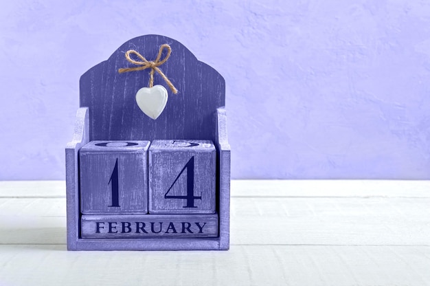 Ewiger Kalender aus Holz am 14. Februar. Valentinstag. Farbe des Jahres 2022 Very Peri. Postkarte. Kopieren Sie Platz für Ihre besseren Projekte.