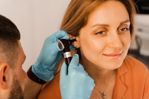 Exame aproximado da orelha da mulher com otoscópio Otoscopia Visita ao otorrinolaringologista e consulta