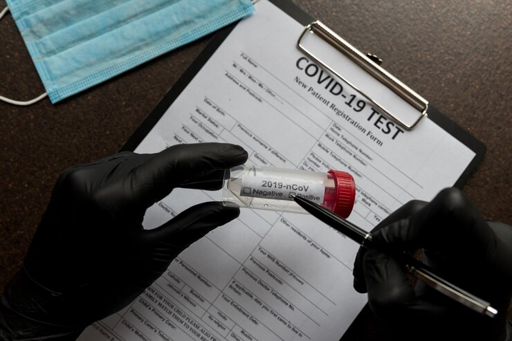 Exame de coronavírus com resultado positivo em um tubo de sangue em um fundo de ficha de registro